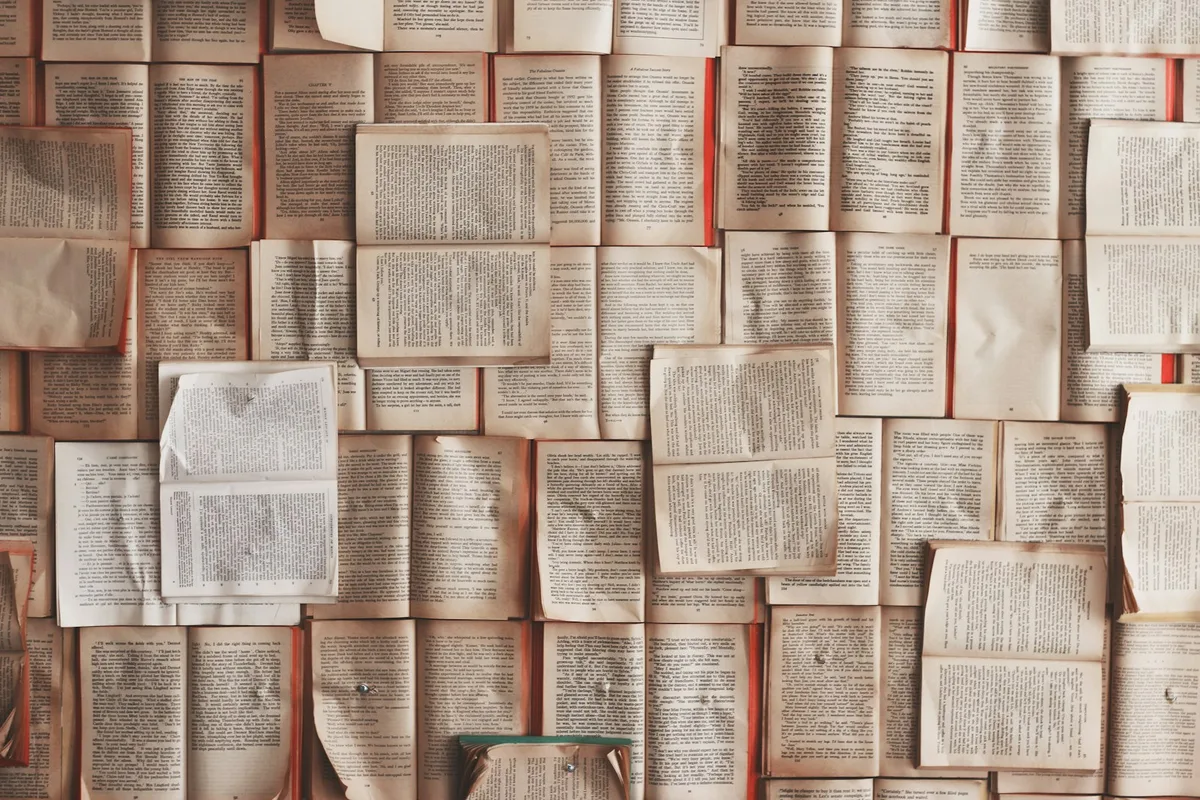 An open book resting on a stack of books.